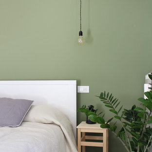 Modelo de dormitorio principal, nórdico, de tamaño medio, con paredes verdes y suelo laminado