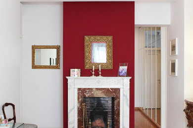 Foto di una grande camera matrimoniale chic con pareti rosse, camino classico, cornice del camino in pietra e parquet chiaro