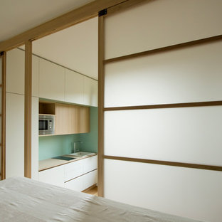 Ejemplo de dormitorio tipo loft, nórdico, pequeño, con suelo de madera clara y suelo marrón