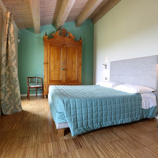 Ispirazione per una camera matrimoniale minimal di medie dimensioni con pareti verdi, pavimento in legno massello medio e pavimento marrone
