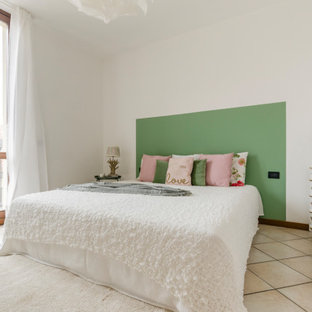 Immagine di una camera da letto mediterranea di medie dimensioni con pareti bianche e pavimento beige
