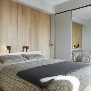Ispirazione per una camera degli ospiti minimal con pareti grigie, parquet chiaro e pavimento beige