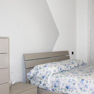 Imagen de dormitorio principal, actual, de tamaño medio, sin chimenea, con paredes grises, suelo de baldosas de porcelana y suelo rosa