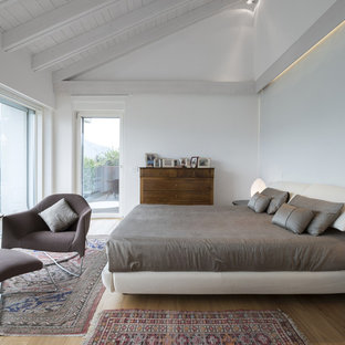 Immagine di una camera da letto contemporanea con pareti bianche, pavimento in legno massello medio e pavimento marrone