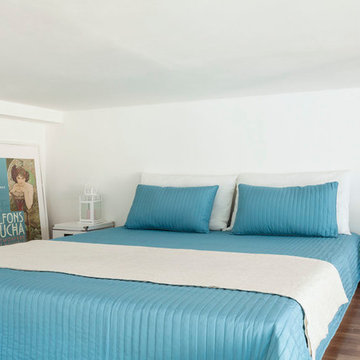 Camera da letto su soppalco con copriletto azzurro