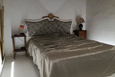 Foto de dormitorio principal clásico de tamaño medio con paredes blancas y suelo de ladrillo