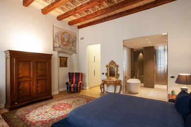 Cette image montre une grande chambre parentale méditerranéenne avec un mur blanc, parquet clair et un sol beige.
