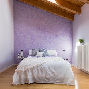 Cette photo montre une chambre parentale nature de taille moyenne avec un mur violet et un sol en bois brun.