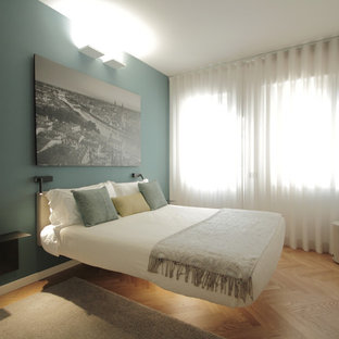 Idee per una camera da letto design con pareti verdi, pavimento in legno massello medio e pavimento marrone