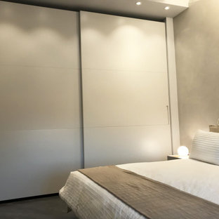 Modelo de dormitorio tipo loft, moderno, de tamaño medio, sin chimenea, con paredes beige, suelo de linóleo y suelo gris