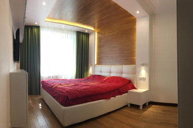 ヴェネツィアにあるコンテンポラリースタイルのおしゃれな主寝室 (白い壁、無垢フローリング、茶色い床) のインテリア