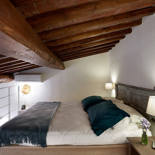 Esempio di una piccola camera da letto stile loft country con pareti bianche, parquet chiaro e pavimento beige