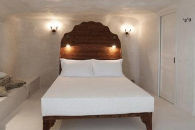 Idee per una camera da letto mediterranea con pareti bianche e pavimento in cemento