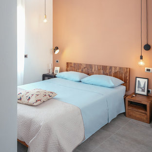 Modelo de dormitorio principal, industrial, con paredes rojas, suelo de baldosas de porcelana y suelo gris