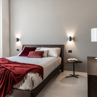 Immagine di una camera da letto design con pareti grigie e pavimento grigio
