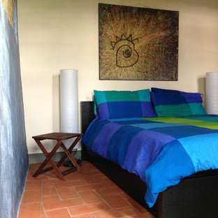 Diseño de dormitorio principal, moderno, grande, con paredes multicolor, suelo de ladrillo y suelo rojo