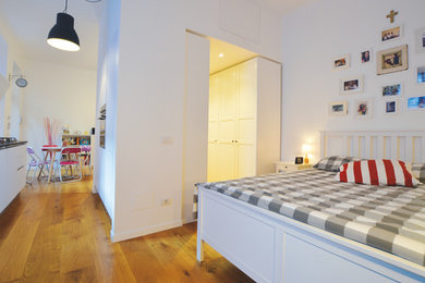 ミラノにある中くらいなコンテンポラリースタイルのおしゃれなロフト寝室 (白い壁、淡色無垢フローリング、茶色い床) のレイアウト
