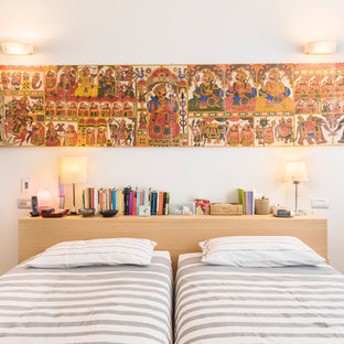 Ispirazione per una camera da letto mediterranea di medie dimensioni con pareti bianche, pavimento in legno massello medio e pavimento marrone