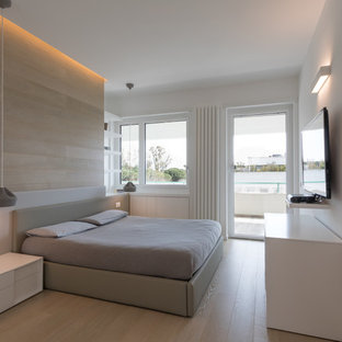 Immagine di una camera da letto minimal con pareti bianche, parquet chiaro e pavimento beige