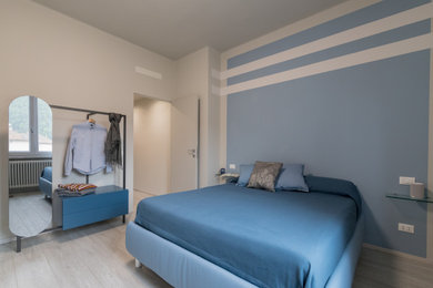 Immagine di una grande camera matrimoniale con pareti blu, pavimento in gres porcellanato e pavimento beige