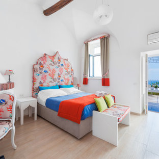 Idee per una grande camera matrimoniale moderna con pareti bianche, pavimento in gres porcellanato, camino ad angolo, cornice del camino in mattoni, pavimento multicolore e soffitto a volta