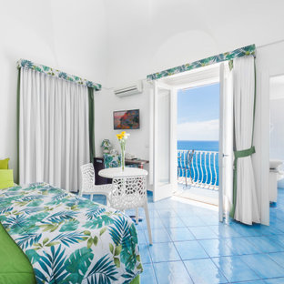 Diseño de dormitorio principal y abovedado, moderno, de tamaño medio, con paredes blancas, suelo de baldosas de porcelana y suelo turquesa