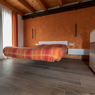 Foto di una camera matrimoniale minimalista di medie dimensioni con pareti arancioni, pavimento in legno verniciato e pavimento marrone