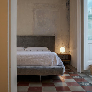 Foto di una camera matrimoniale mediterranea con pareti grigie, pavimento multicolore e pavimento in cemento