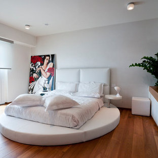 Ispirazione per una camera da letto moderna con pareti bianche, pavimento in legno massello medio e pavimento marrone