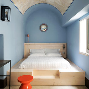 Immagine di una camera da letto mediterranea con pareti blu, nessun camino, pavimento beige e letto davanti alla finestra
