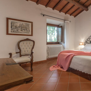 Foto di una camera da letto mediterranea con pareti bianche e pavimento marrone