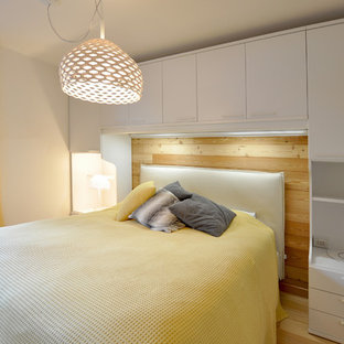 Aménagement d'une chambre contemporaine avec un mur blanc, un sol en bois clair et un sol beige.