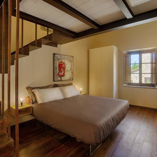 Foto di una camera da letto contemporanea con pareti beige, pavimento in legno massello medio e pavimento marrone