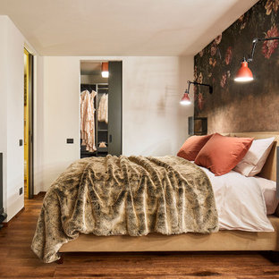 Immagine di una camera da letto contemporanea con pareti multicolore, pavimento in legno massello medio, pavimento marrone e carta da parati