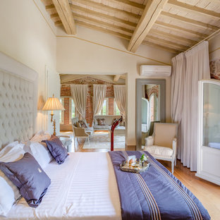 Foto di una camera da letto tradizionale con pareti beige, parquet chiaro e pavimento beige