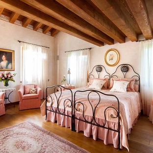 Esempio di una camera da letto chic con pareti bianche, pavimento in legno massello medio e pavimento marrone