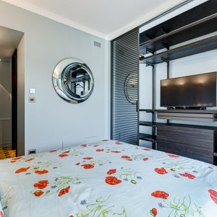 Idee per una camera da letto minimal di medie dimensioni con pareti grigie, parquet chiaro, pavimento marrone e pannellatura