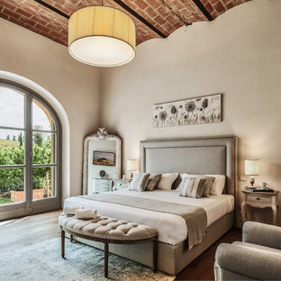 Esempio di una grande camera matrimoniale mediterranea con pareti grigie, parquet chiaro, pavimento beige e soffitto a volta