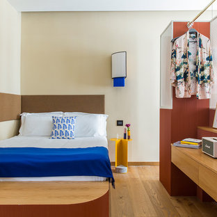 Ispirazione per una grande camera da letto minimal con pareti beige, pavimento in legno massello medio e pavimento marrone