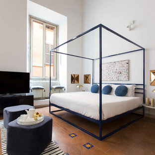 Idée de décoration pour une chambre design avec un mur blanc, un sol en carreau de terre cuite et un sol rouge.