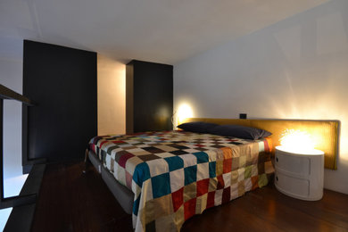 Modelo de habitación de invitados contemporánea pequeña con paredes negras y suelo de madera oscura