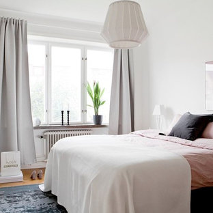 Esempio di una camera da letto scandinava con pareti bianche, pavimento in legno massello medio e pavimento marrone