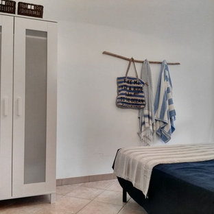 Ejemplo de habitación de invitados rústica, pequeña, con paredes blancas, suelo de baldosas de cerámica y suelo rosa