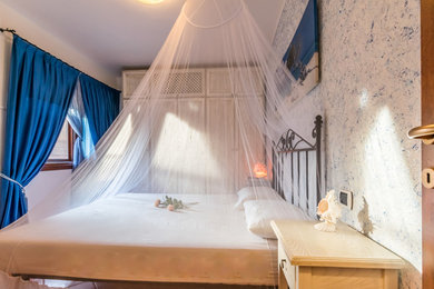 Immagine di una camera matrimoniale stile marinaro con pareti bianche e pavimento in gres porcellanato