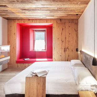 Idee per una camera da letto moderna con pareti bianche, parquet chiaro e camino classico