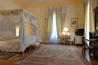Idee per un'ampia camera matrimoniale chic con pareti beige, parquet chiaro e pavimento marrone