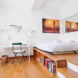 Immagine di una camera matrimoniale design con pareti bianche e pavimento in legno massello medio