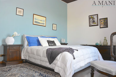 Foto di una camera matrimoniale country di medie dimensioni con pareti blu e pavimento in legno massello medio