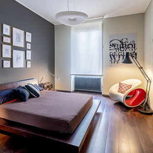 Esempio di una camera da letto contemporanea con pareti grigie, pavimento in legno massello medio e pavimento marrone