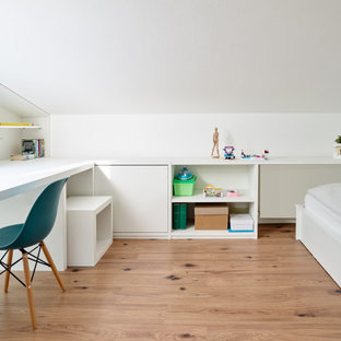 Modelo de dormitorio contemporáneo, pequeño, con paredes blancas, suelo laminado y suelo marrón